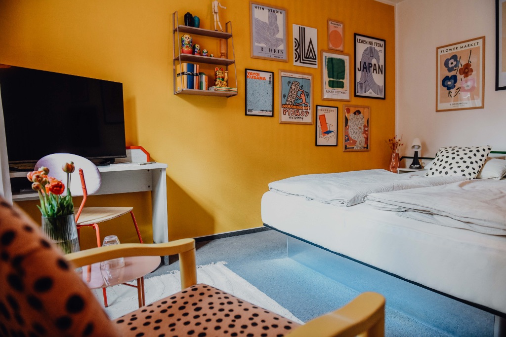sleepArt room for 2 · room overview with bed, desk and poster wall